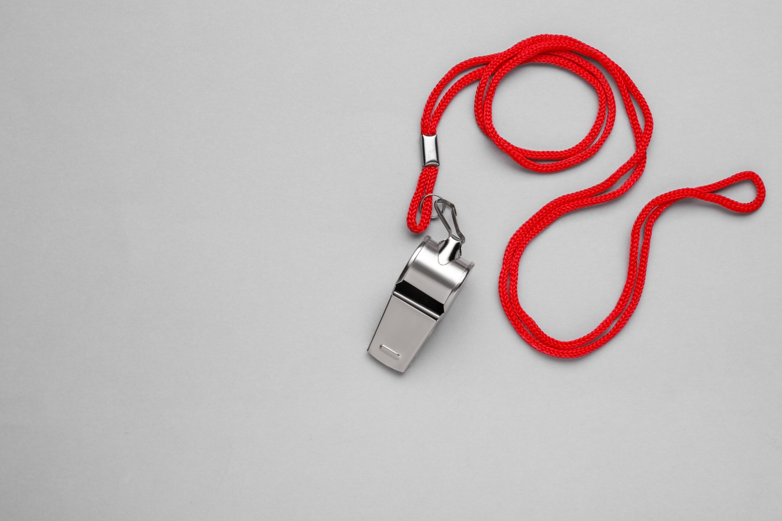 Metal whistle on a red rope.