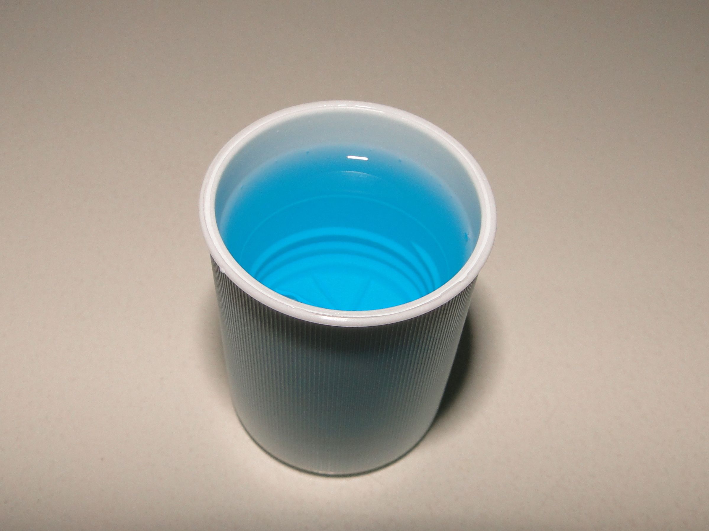 A small cup of mouthwash.