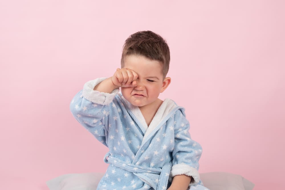A cranky little boy refusing to go to bed