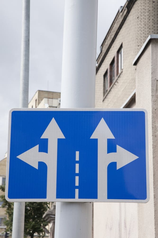Blue and white double headed arrow on traffic sign
