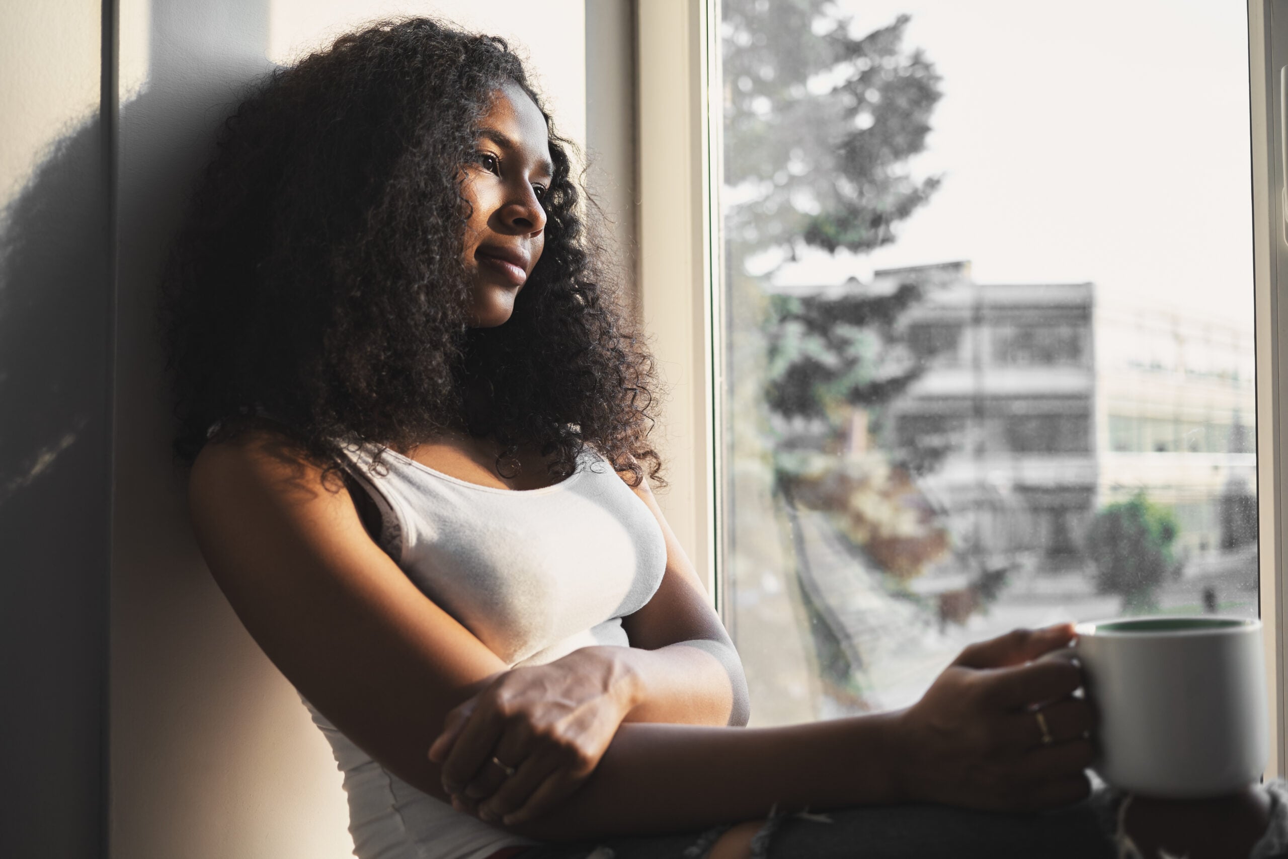A woman siting alone with her thoughts and a cup of tea.