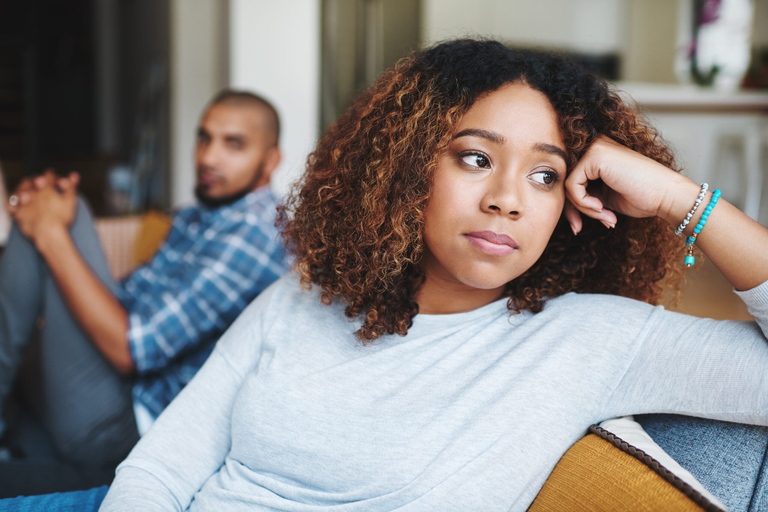 An emotionally unavailable woman looking away from her boyfriend during a disagreement.