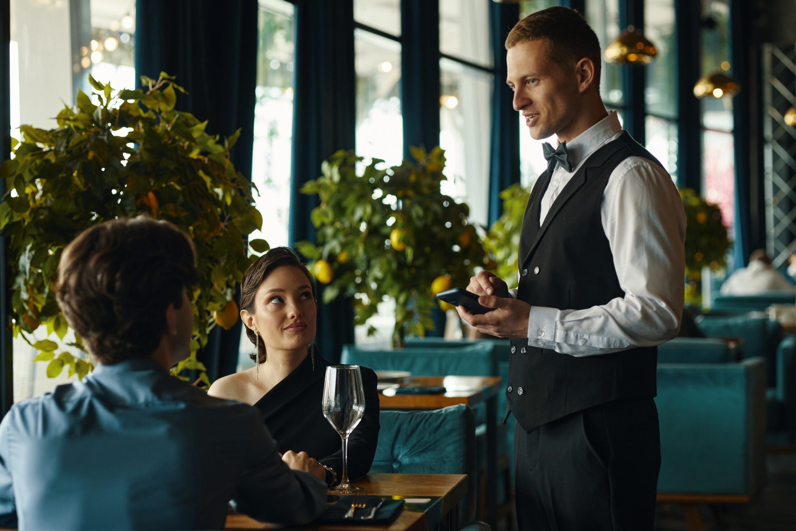 A couple ordering wine at a fancy restaurant.