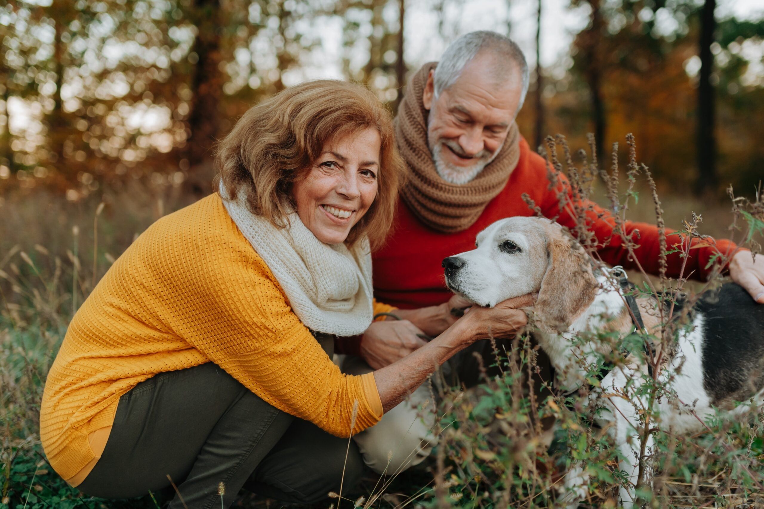 A happily married senior couple with their dog.