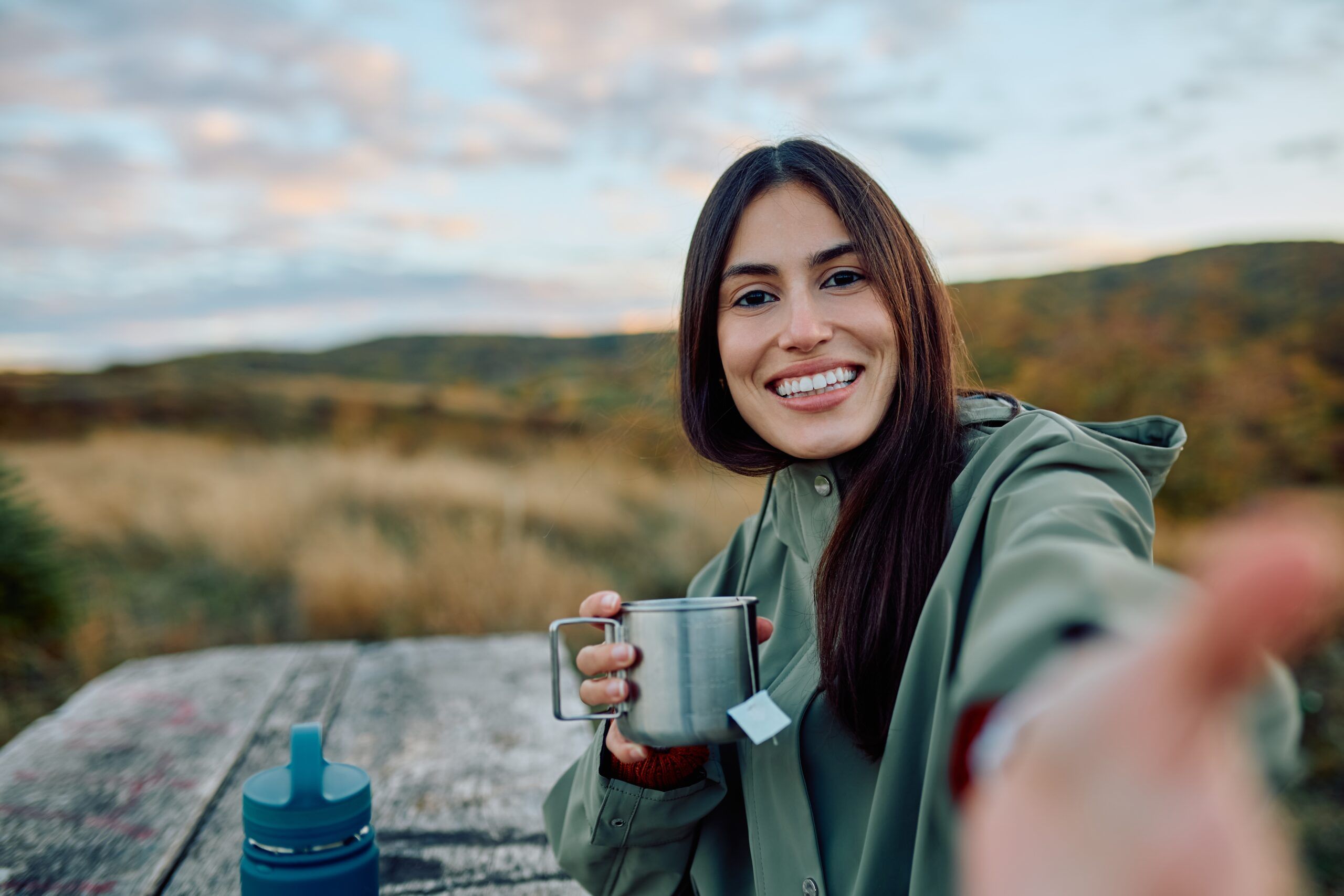 Woman on a solo hike enjoying a cup of tea.