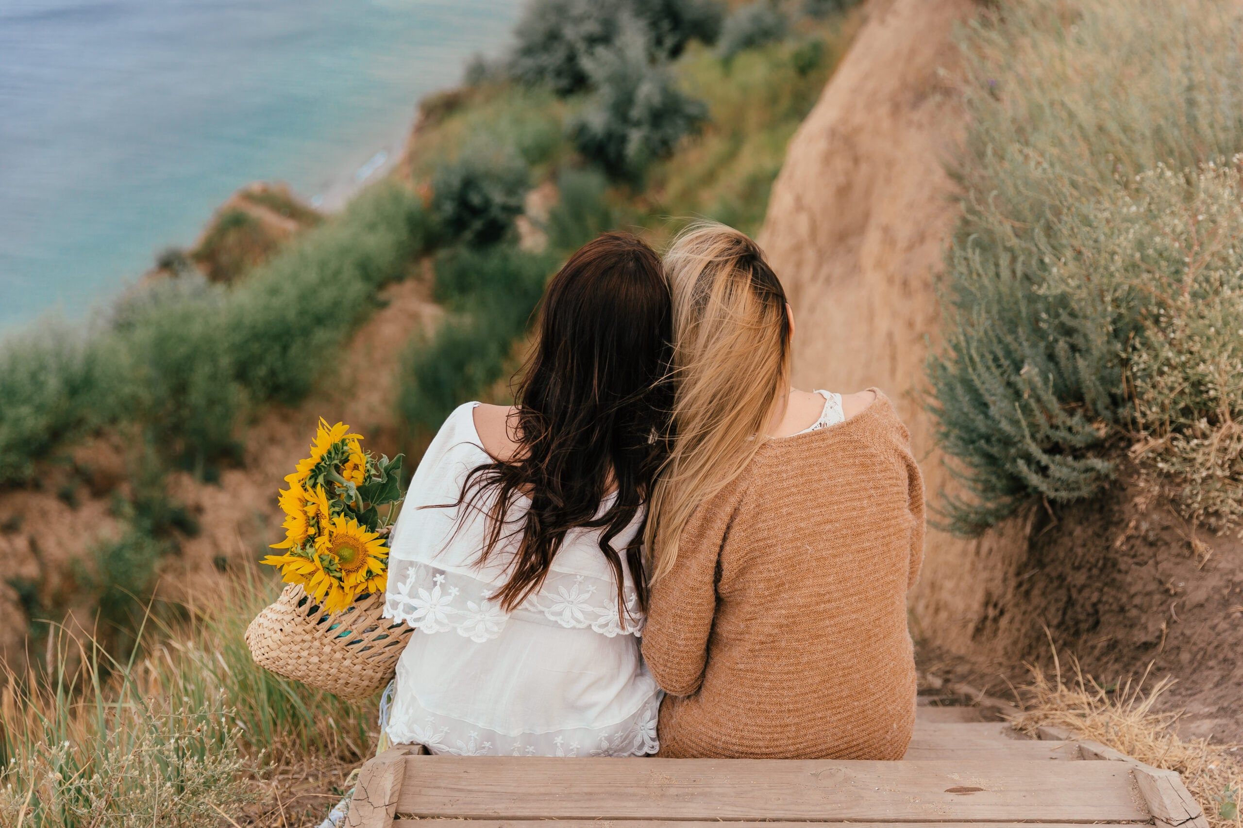 Girlfriends siting together by the sea.