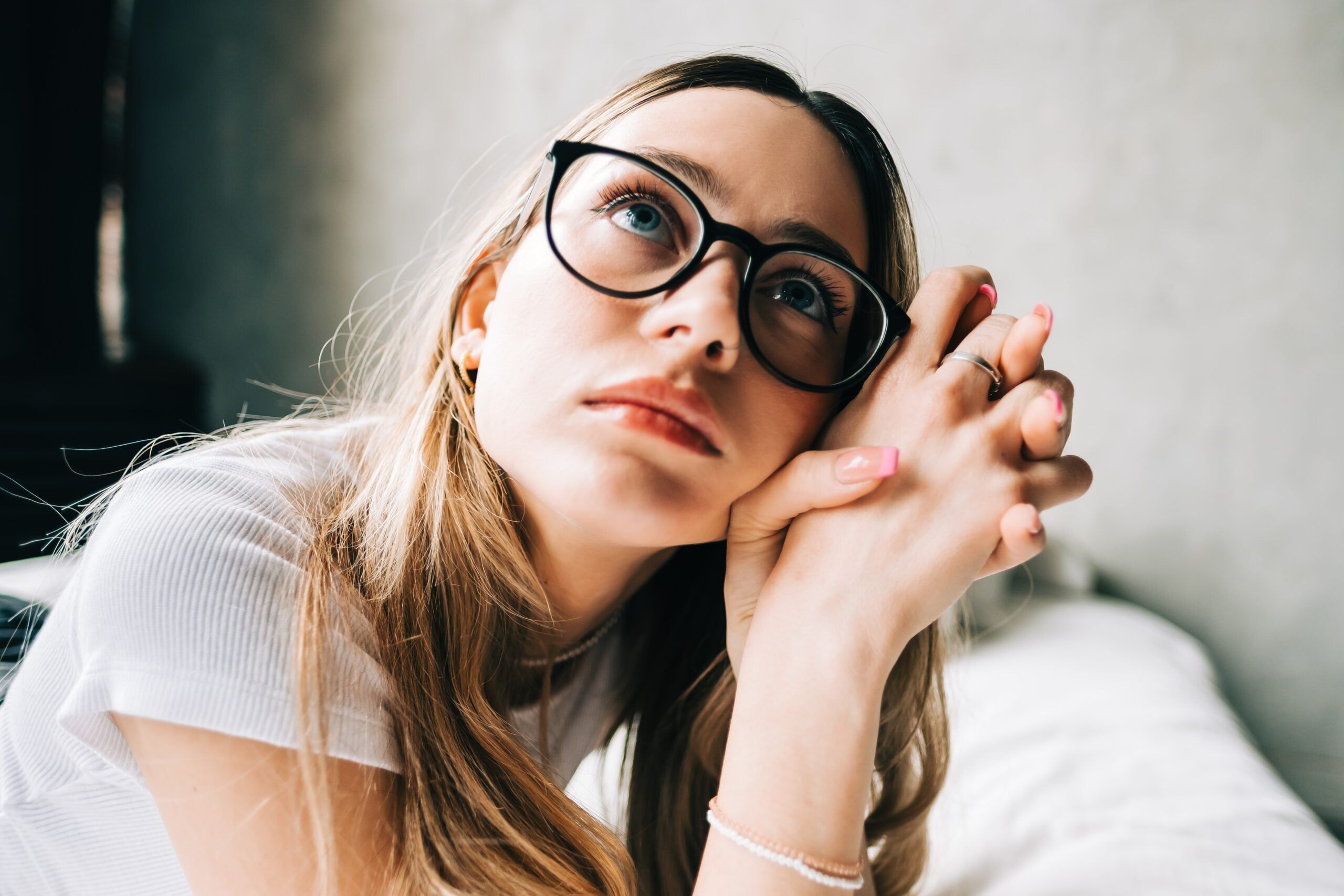 Young woman lying on a bed alone at home.