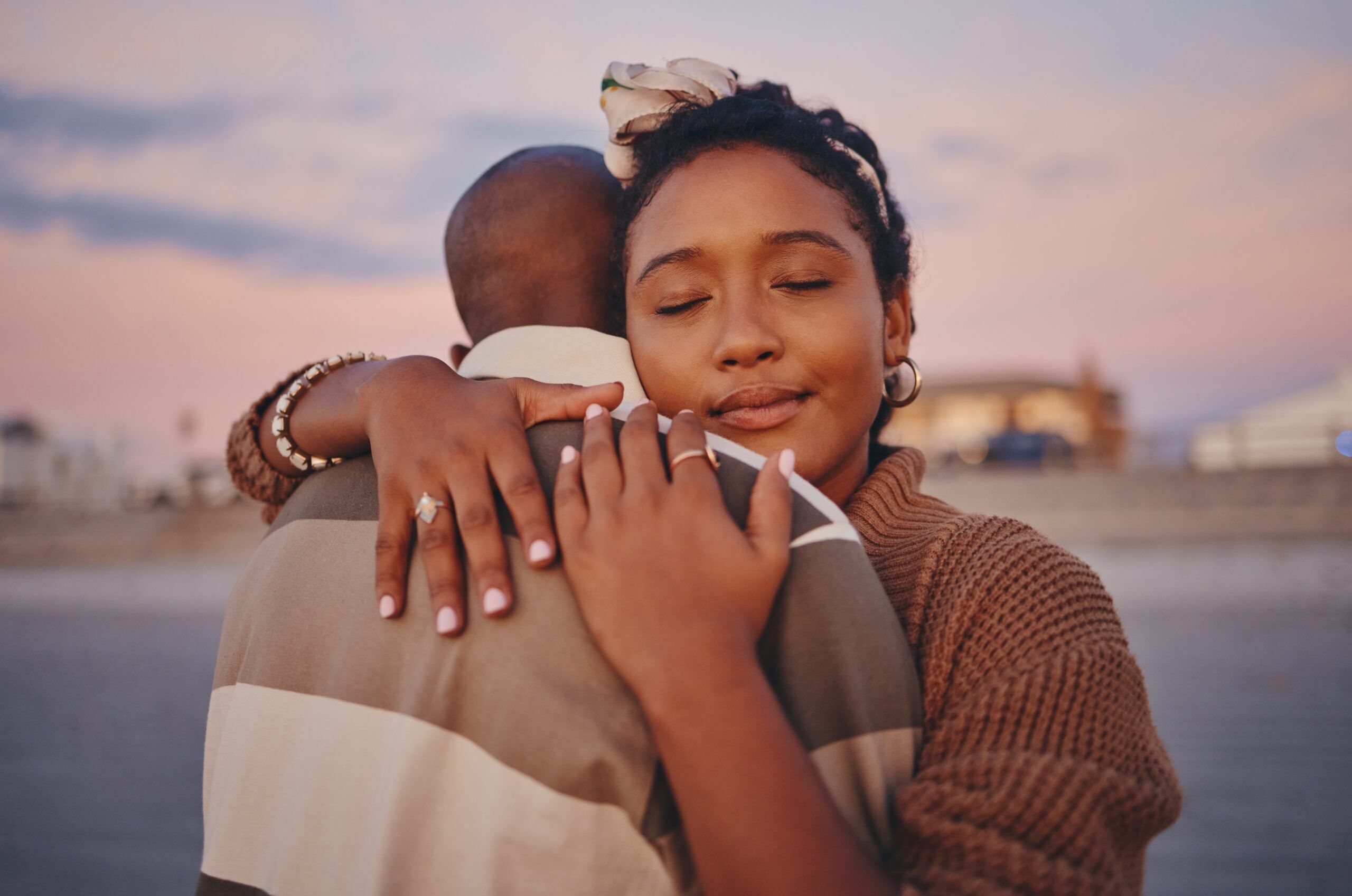 A couple hugging one another on the beach.