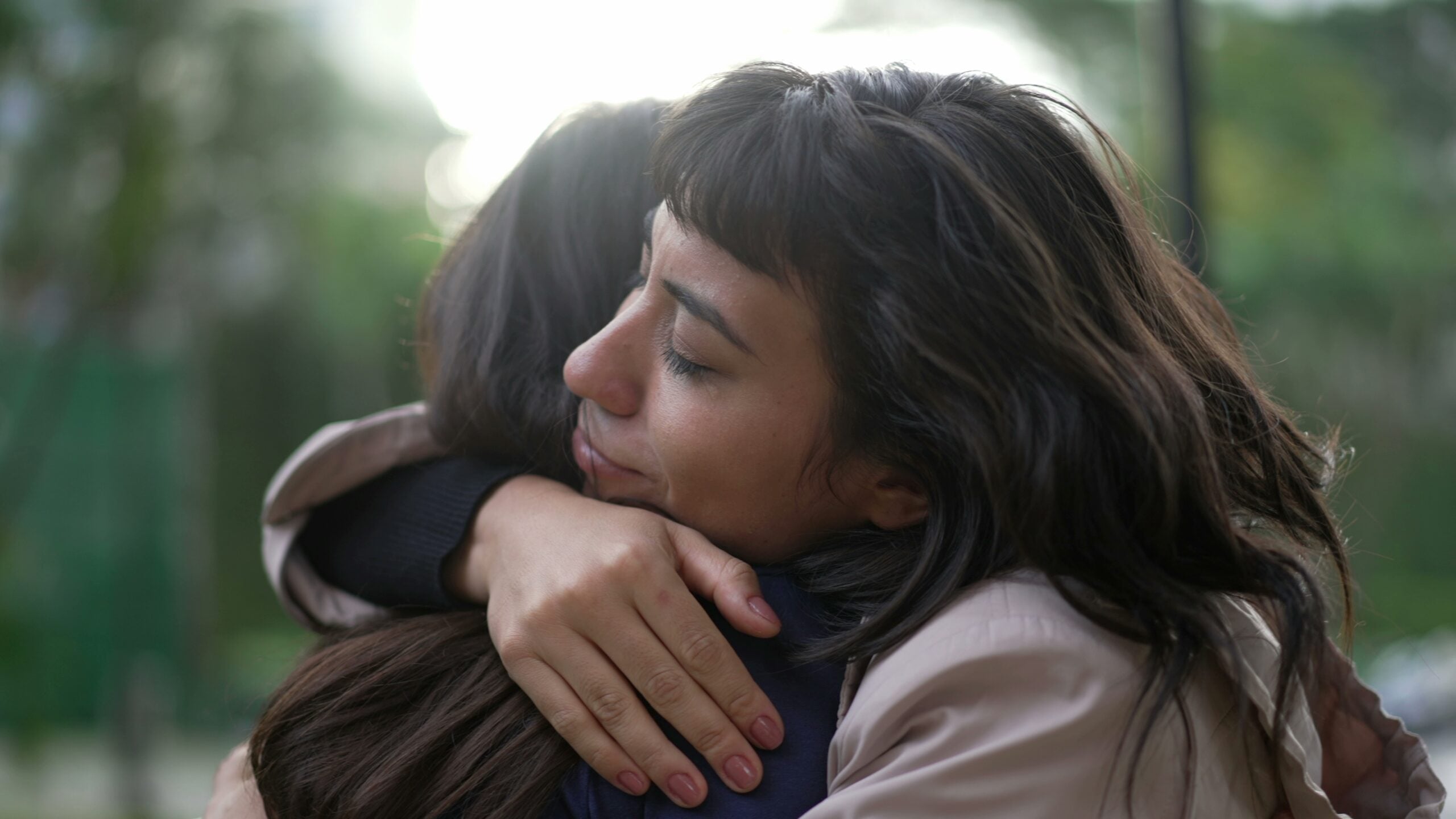 A friend being emotionally supportive with a hug.