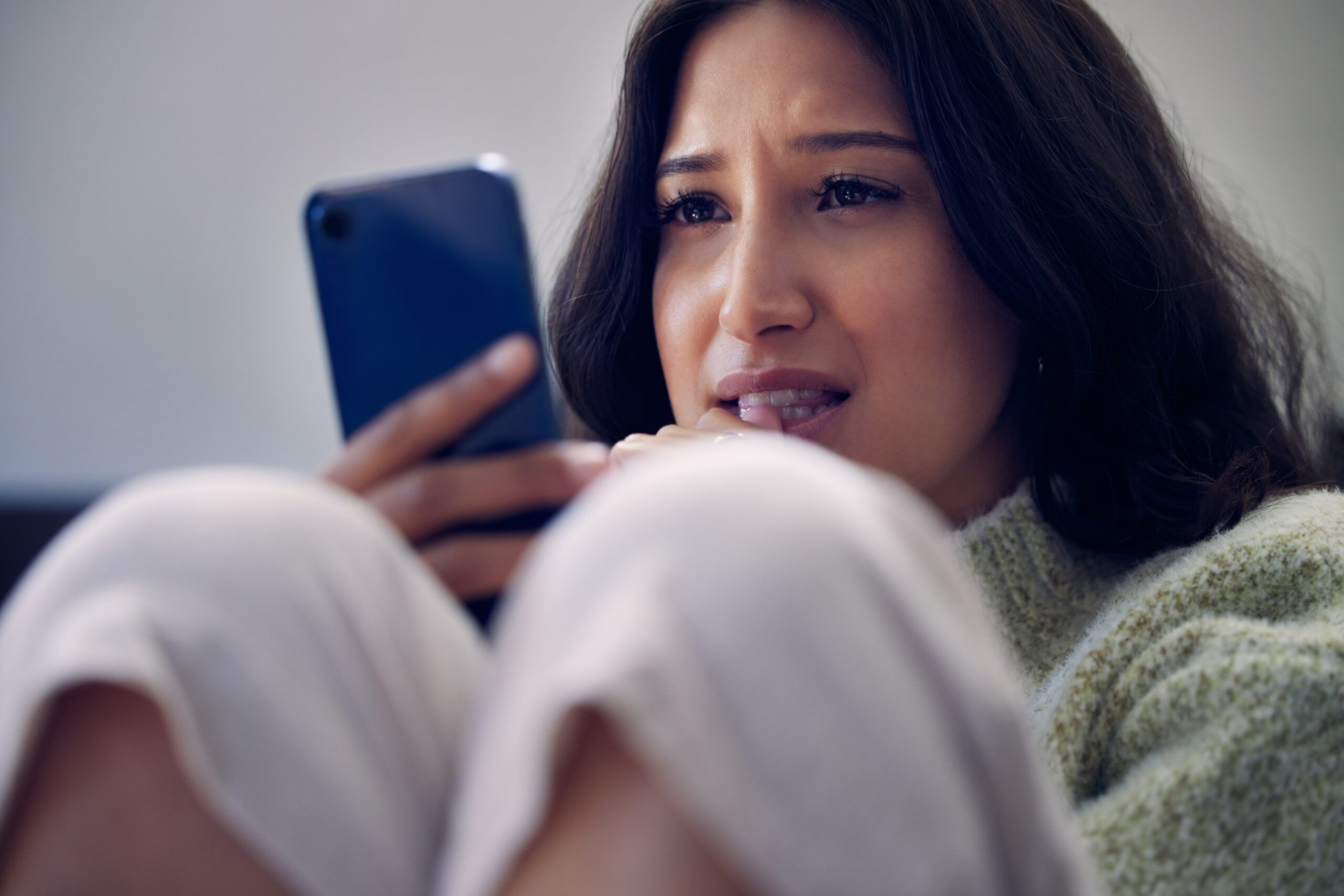 A woman at home cancelling plans to stay in for the evening.