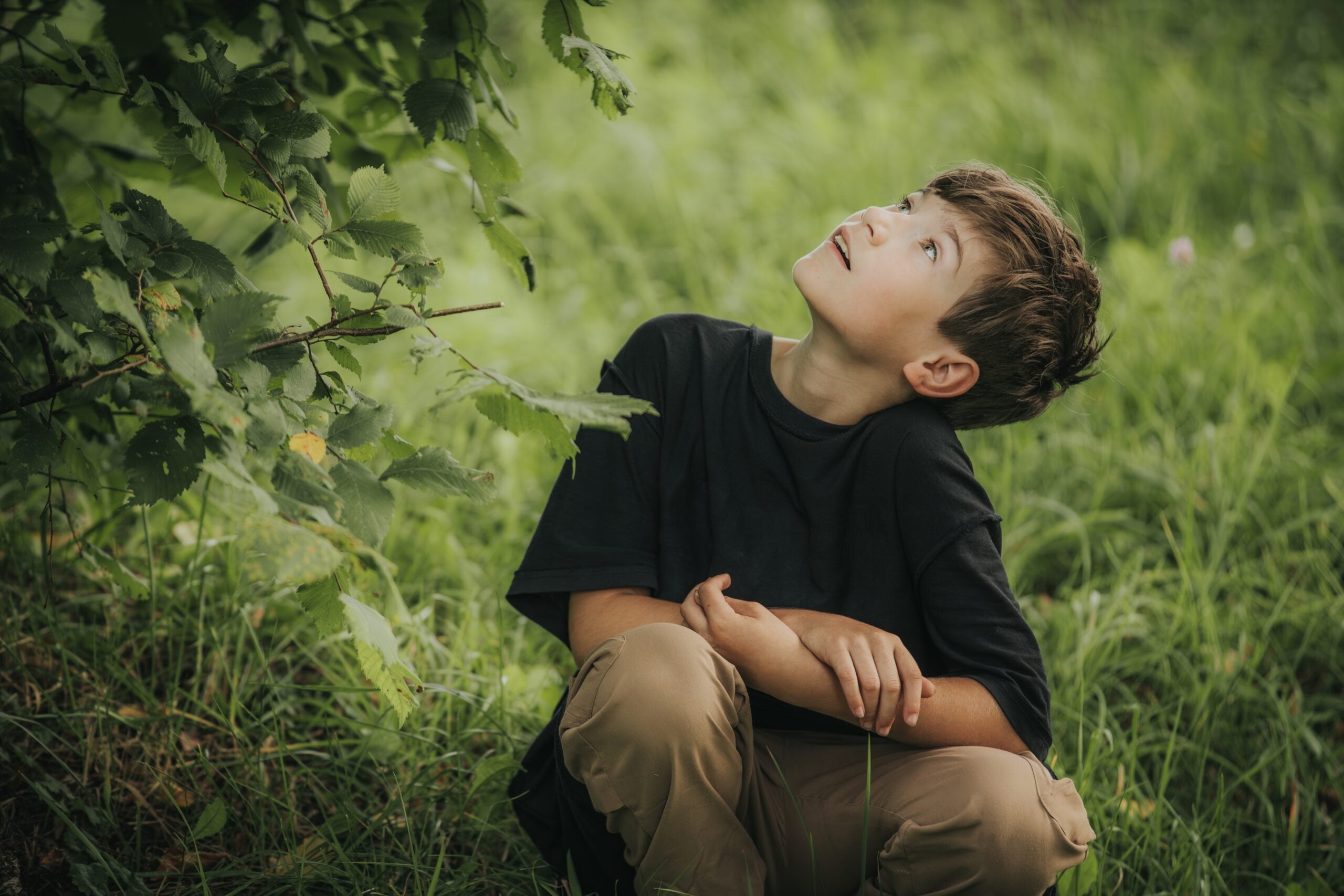 A young boy alone on a walk in the woods.