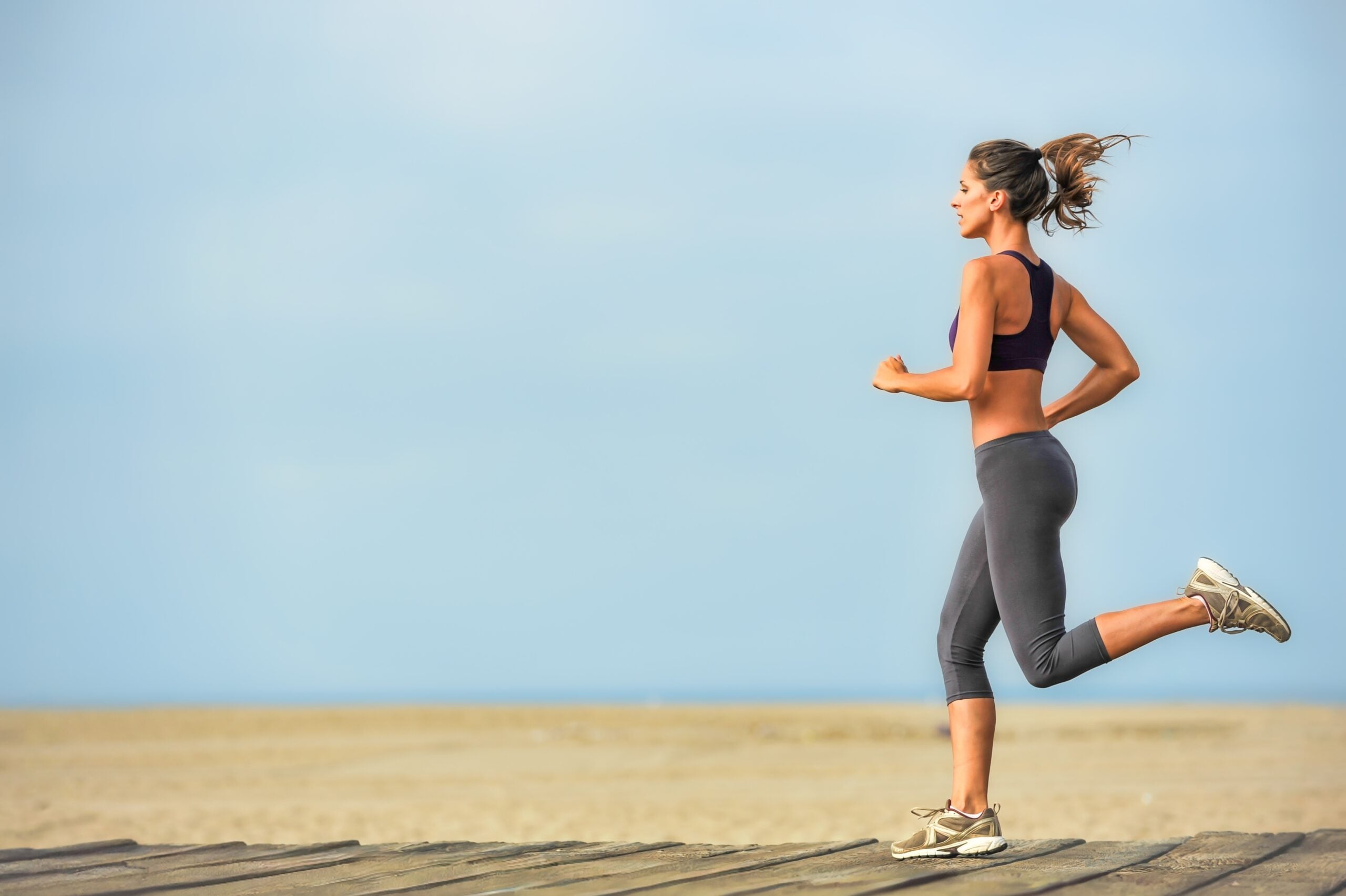 A woman running on the beach during her vacation.