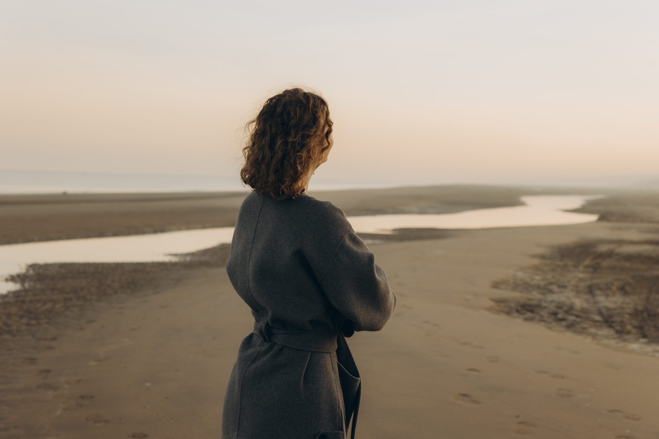 Woman on beach staring at the horizon.