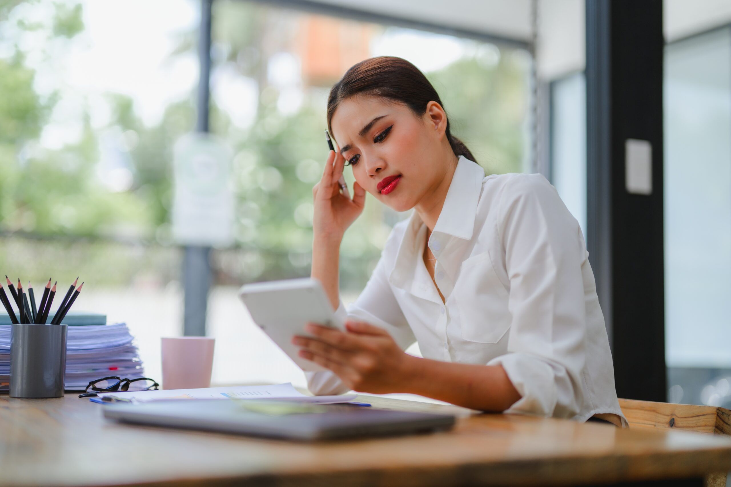 Woman at her desk overwhelmed with work.