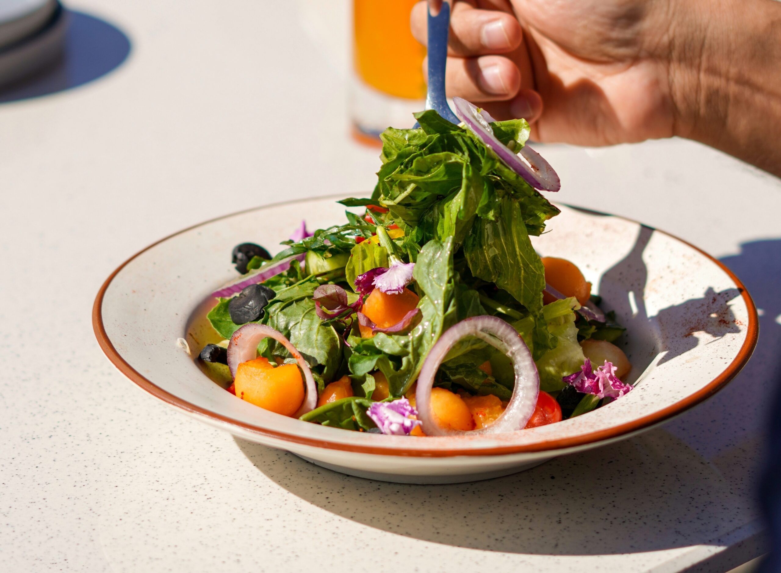 A man enjoying a green salad for lunch.