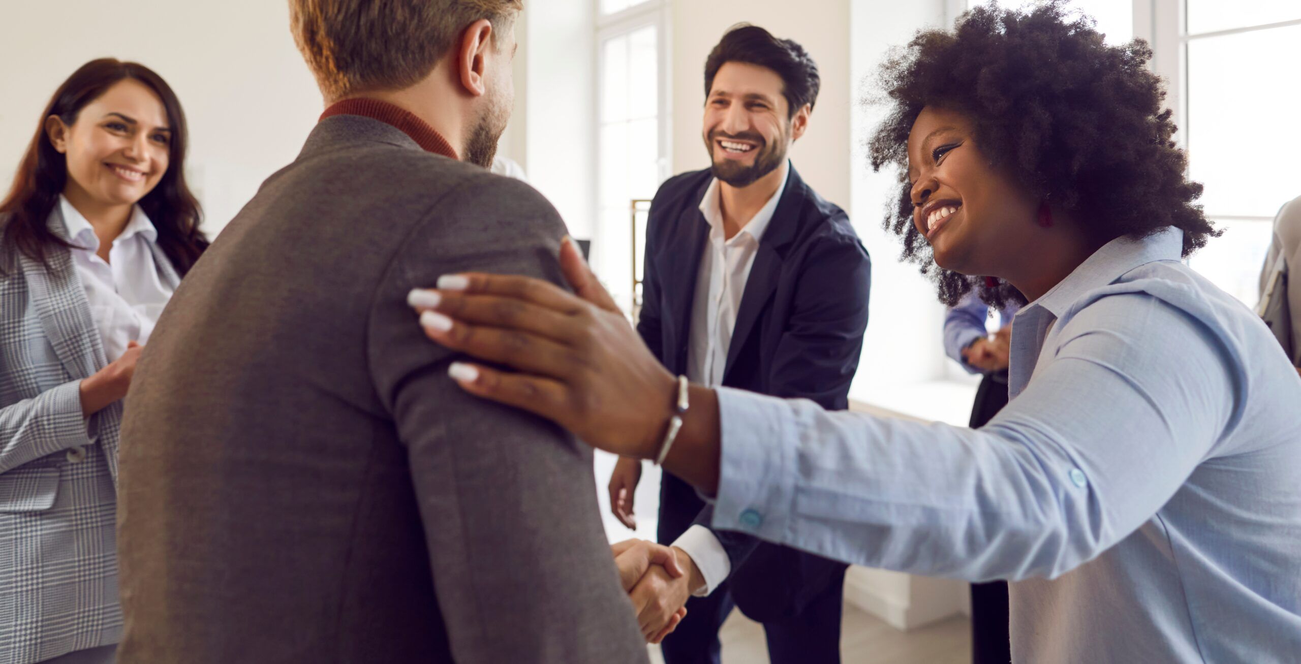 A group of colleagues complimenting a coworker.