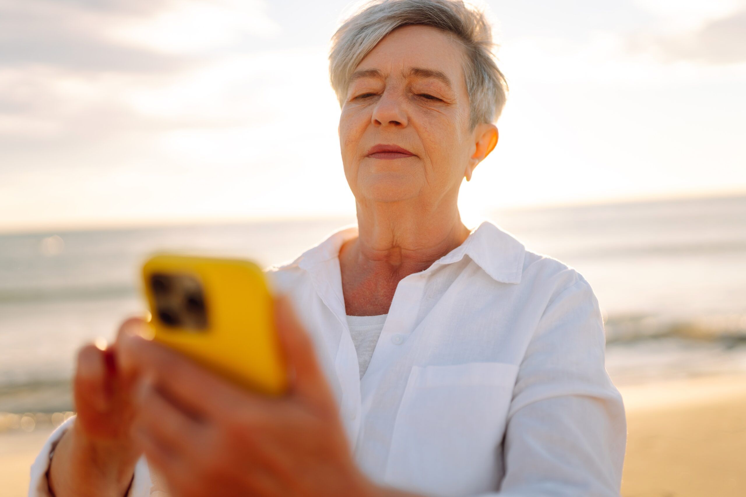A senior woman using social media on her phone.