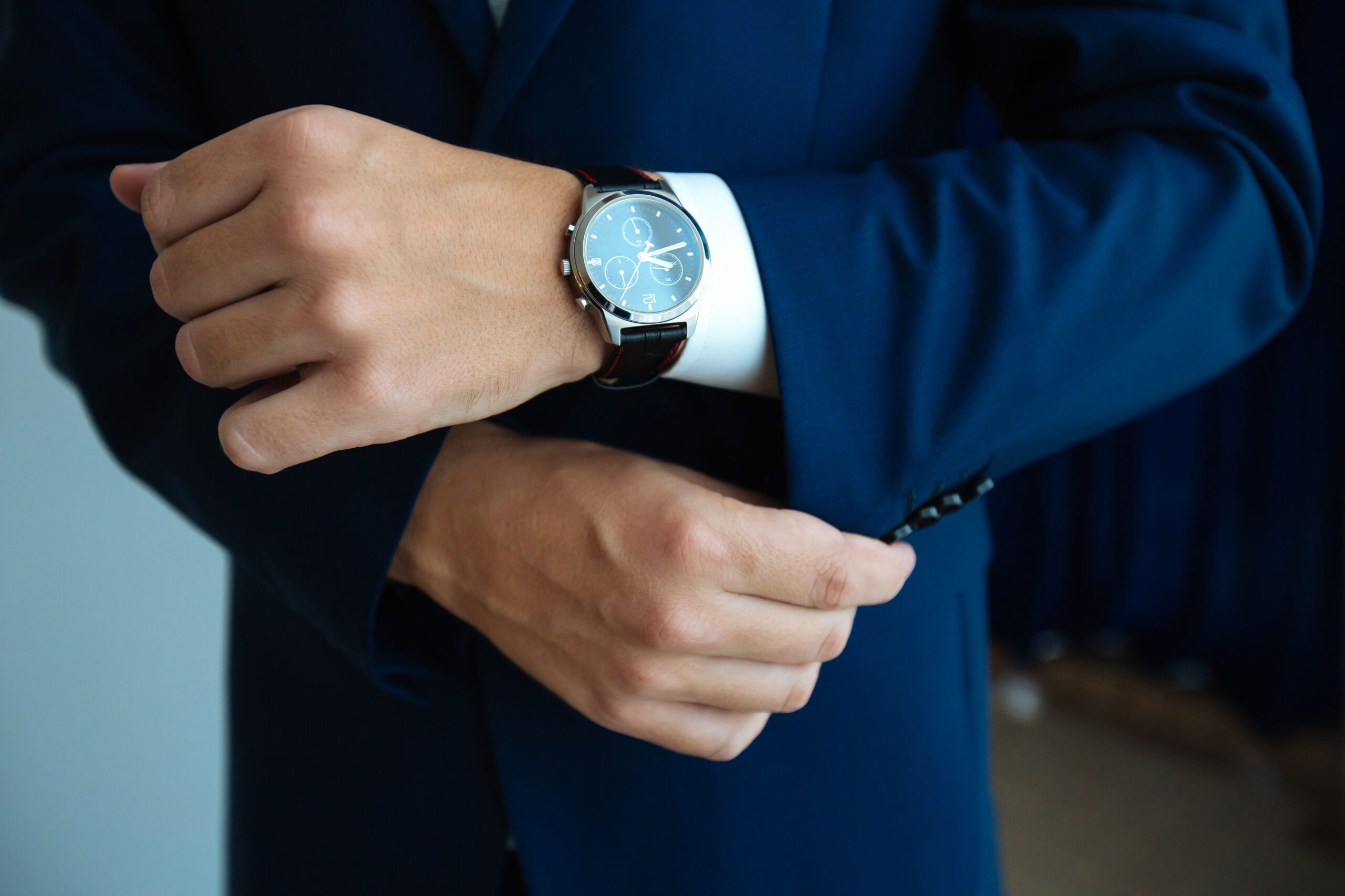 A man dressed in a nice suit with an expensive watch.