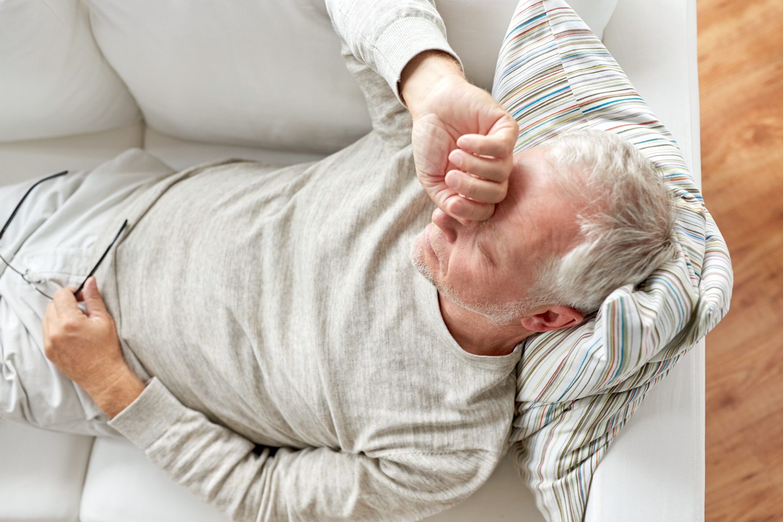 A retired senior feeling tired on the couch.