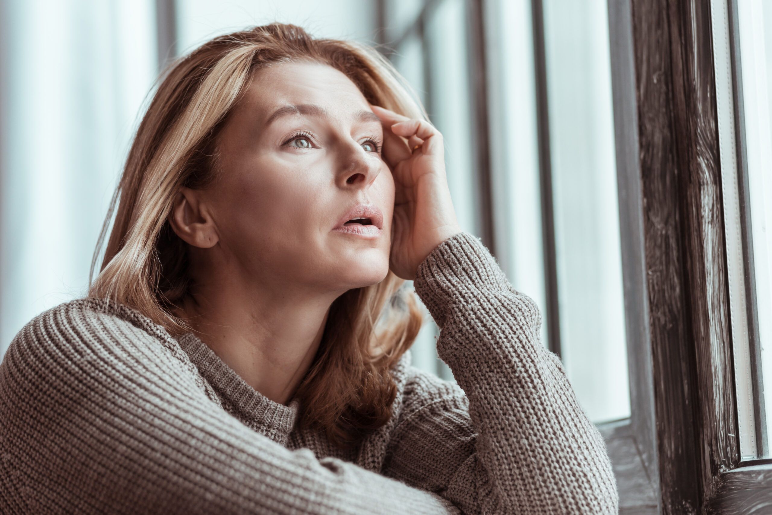 A mature woman in deep thought about her life's decisions.