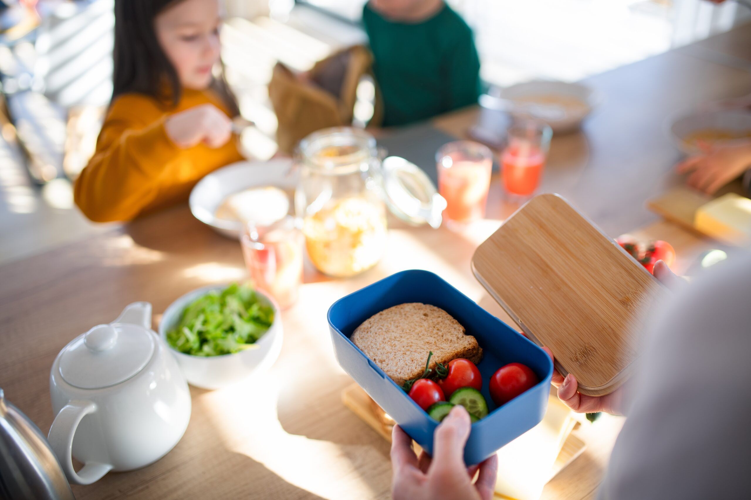 A mother prepping school lunches for her young children.