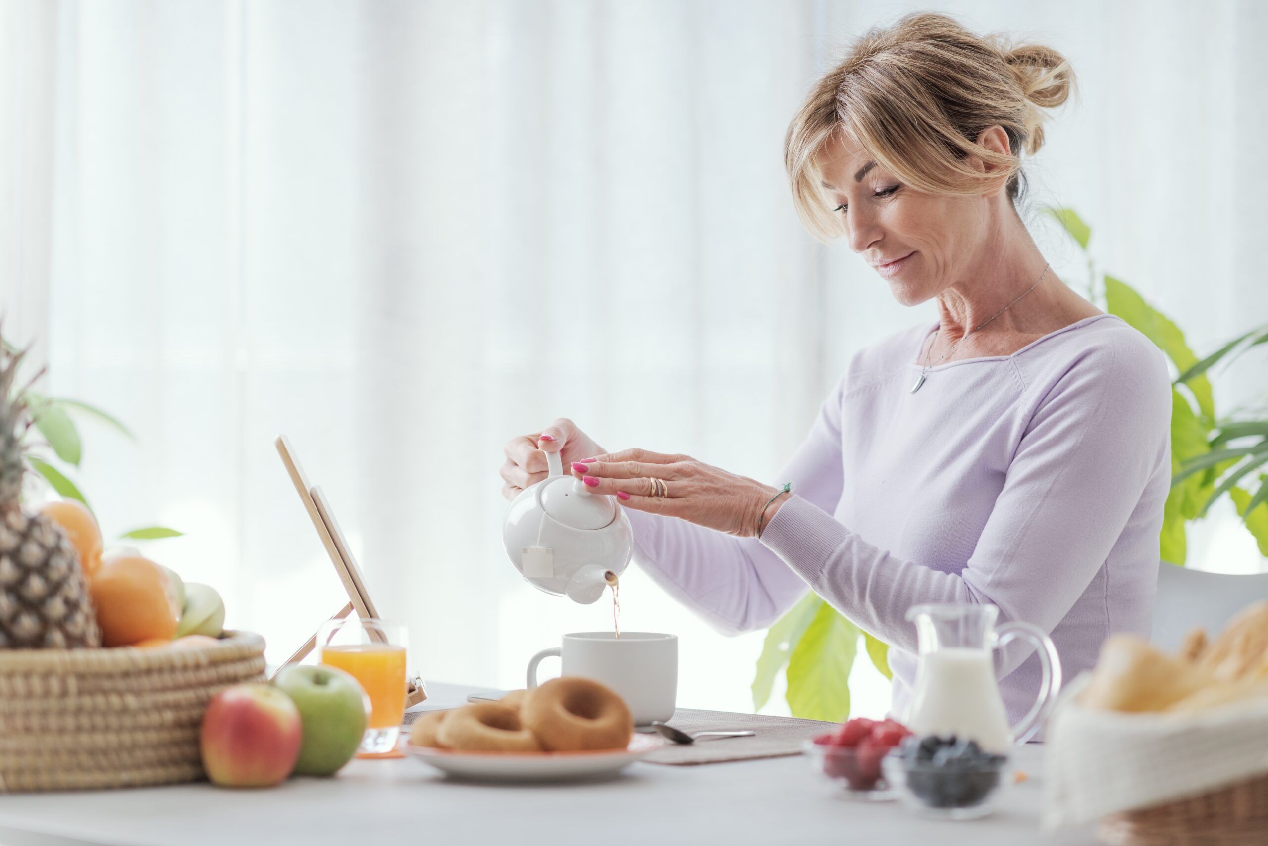 A mature woman having breakfast at home alone.