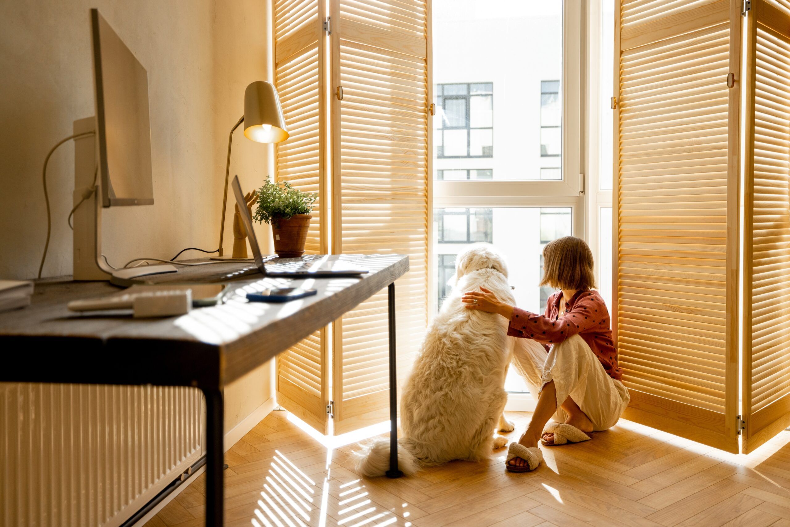 A woman sitting at home with her dog.