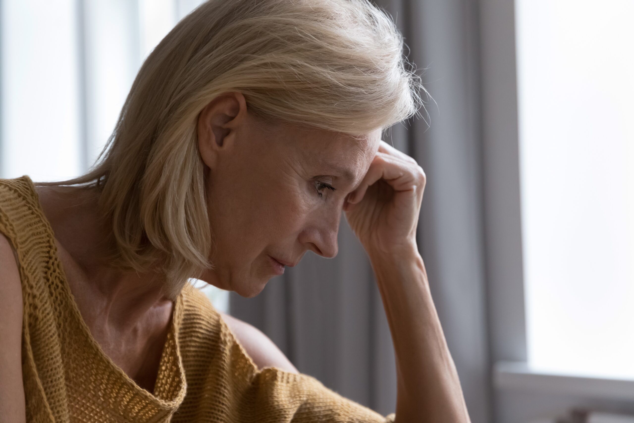 A middle aged woman deep in lonely thoughts.