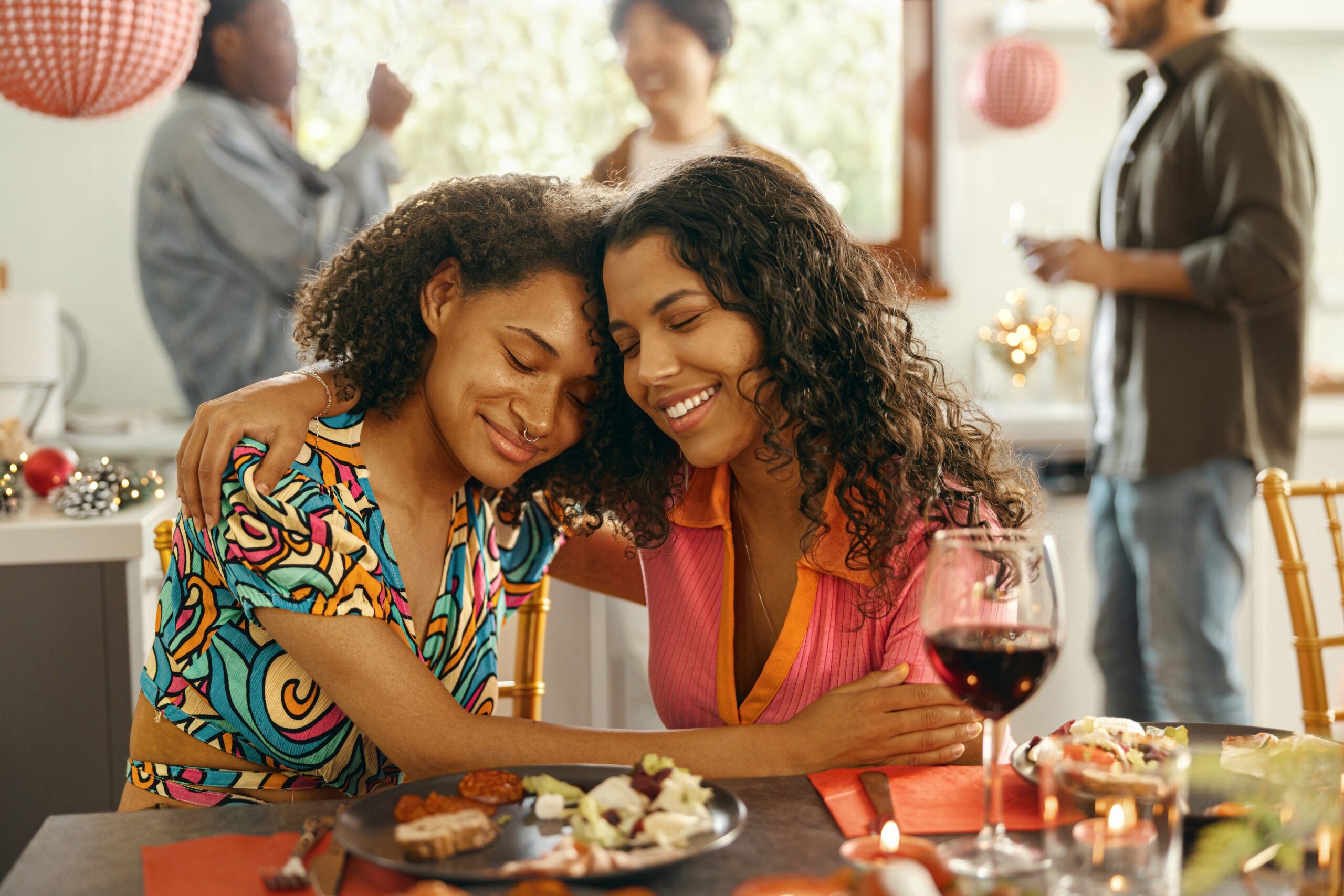 Two female friends embracing over lunch.