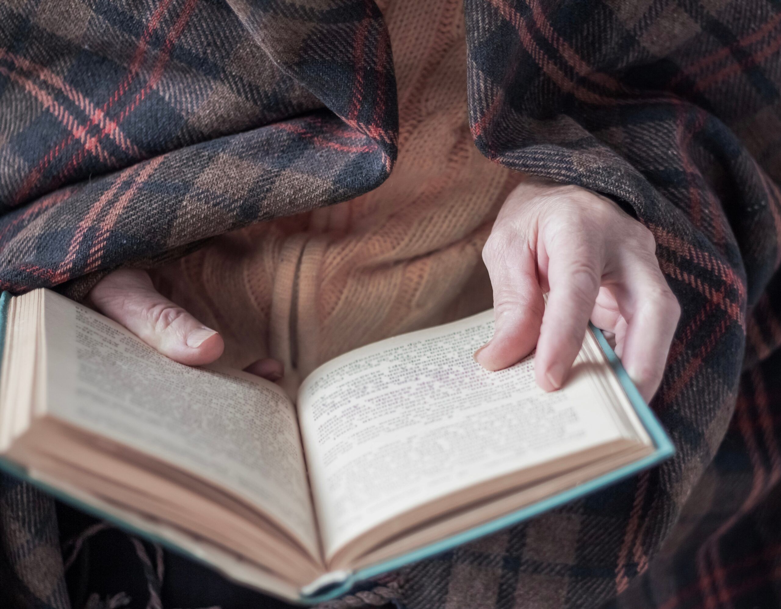 A senior woman sitting alone with her book.