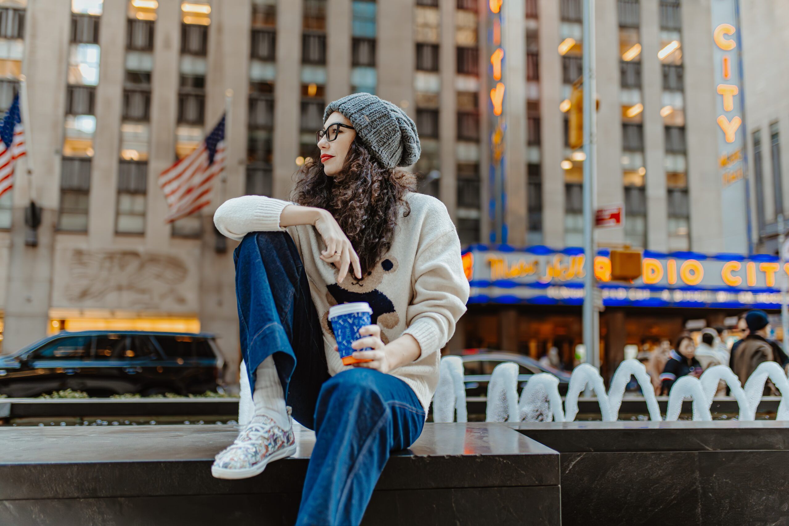 A woman sitting alone at Rockefeller Center in New York City.