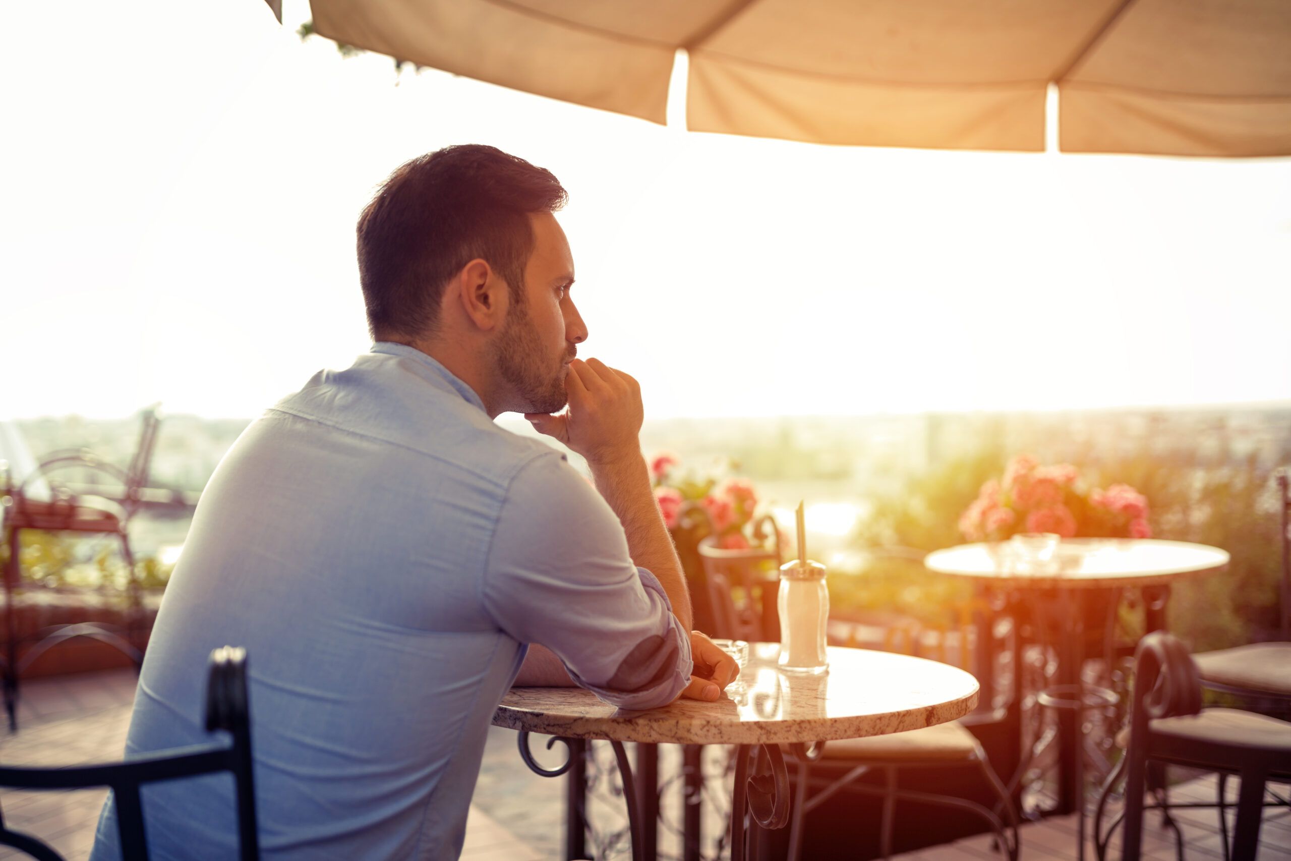 A single man at dinner alone at sunset.