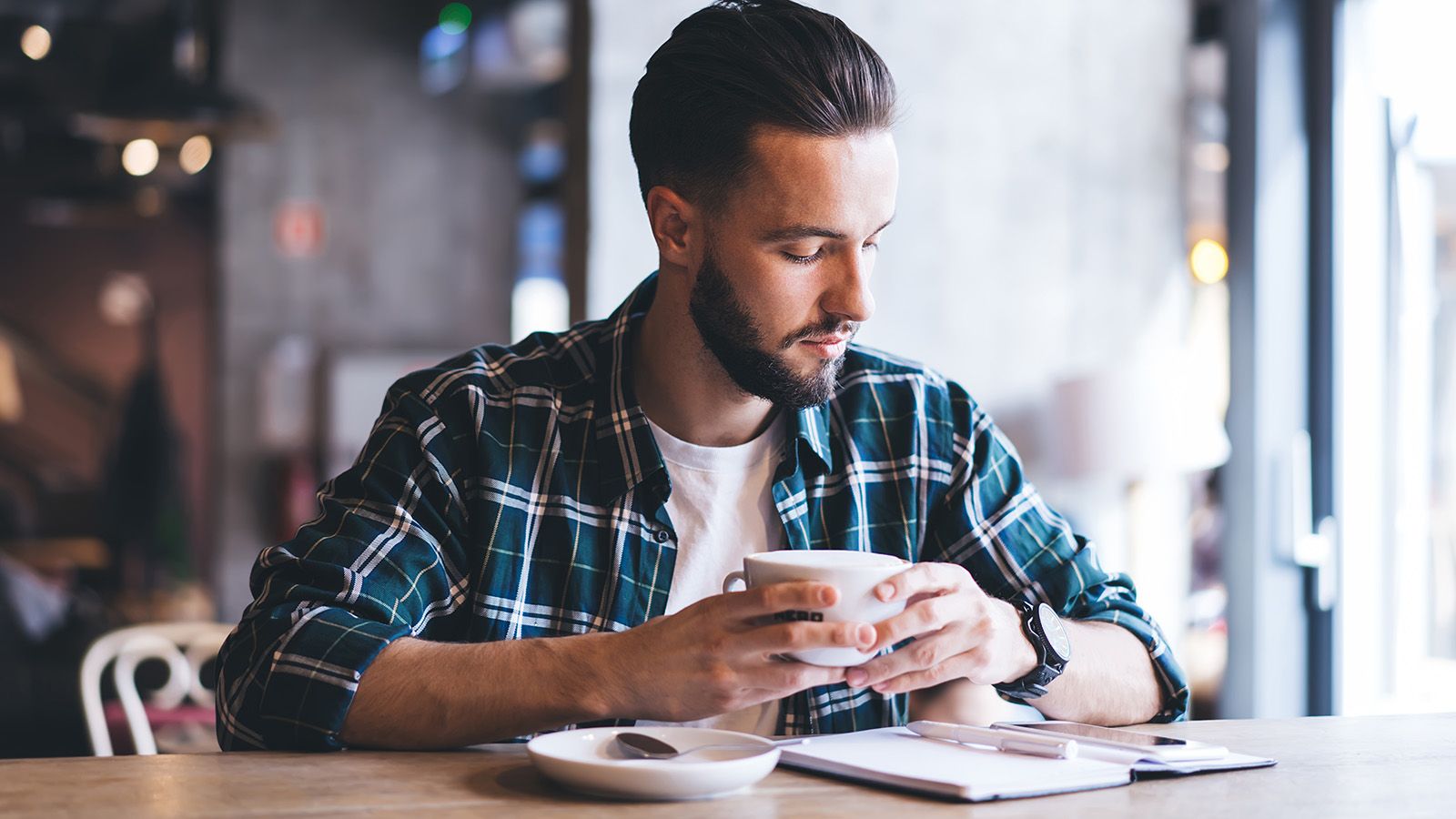Man journaling at a coffee shop.