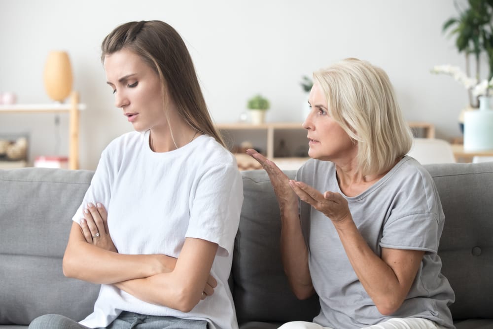 An upset young lady with her back turned against an older woman