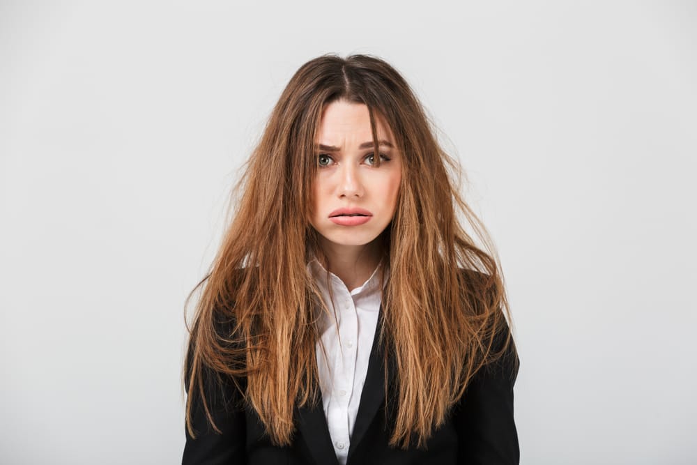 An exhausted businesswoman wearing a suit and her hair is messy