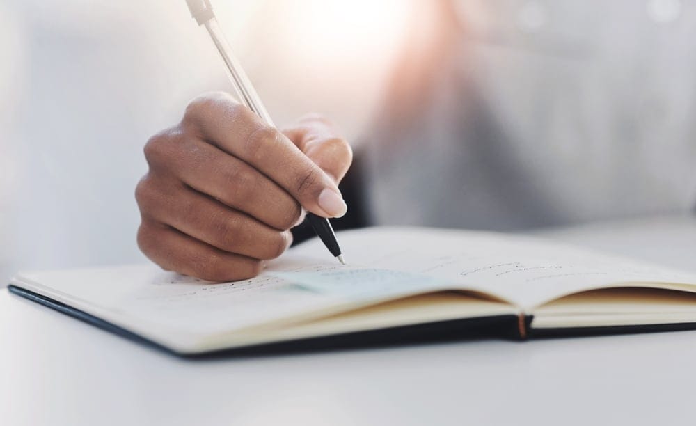 A hand writing in a book
