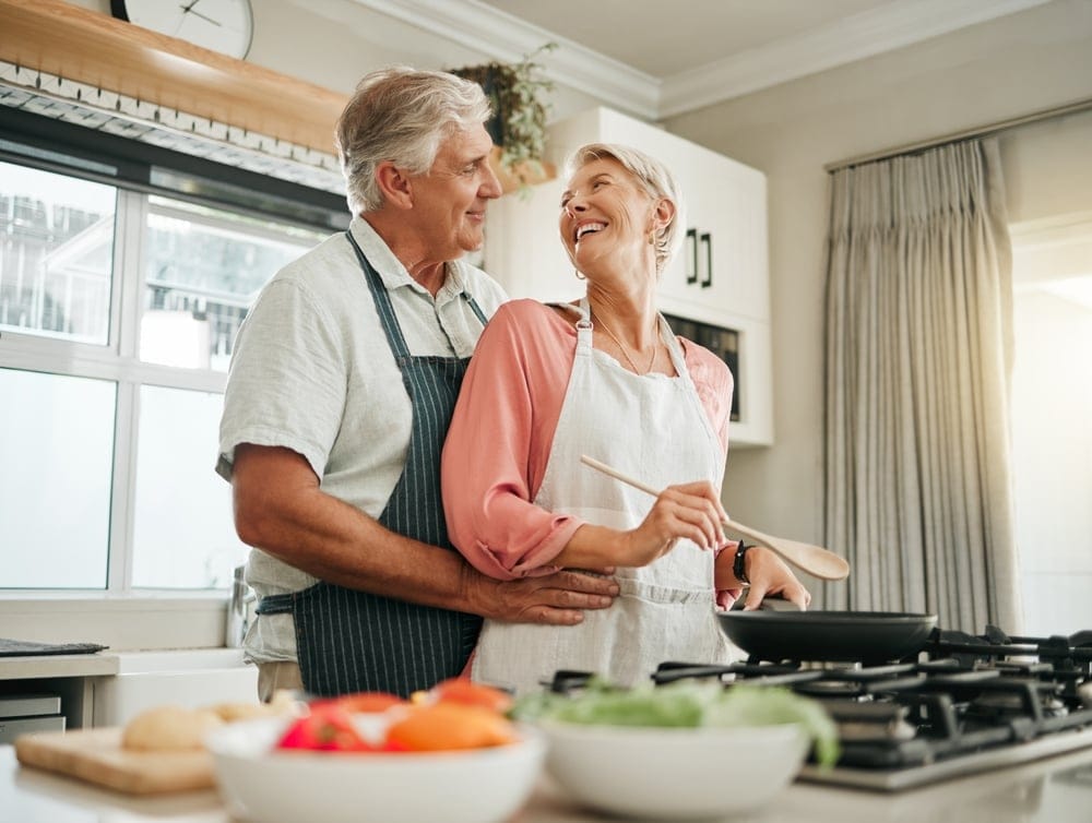 Senior couple cooking and having fun together in the kitchen.
