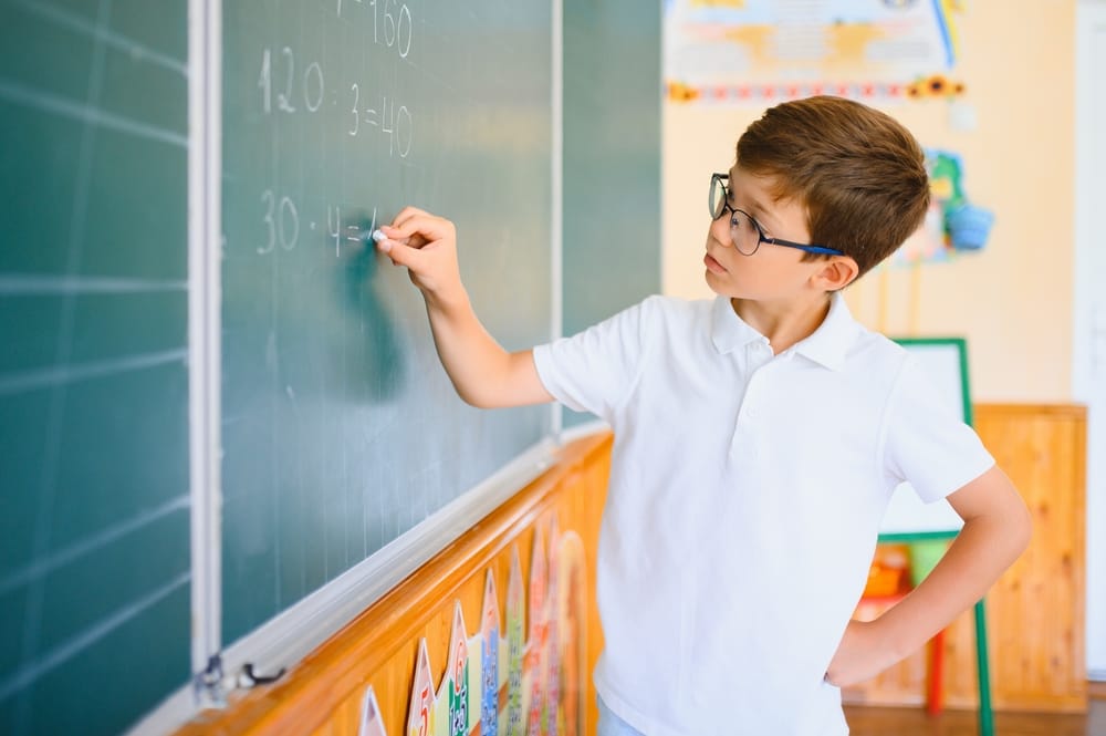 Schoolboy at the chalkboard doing math.