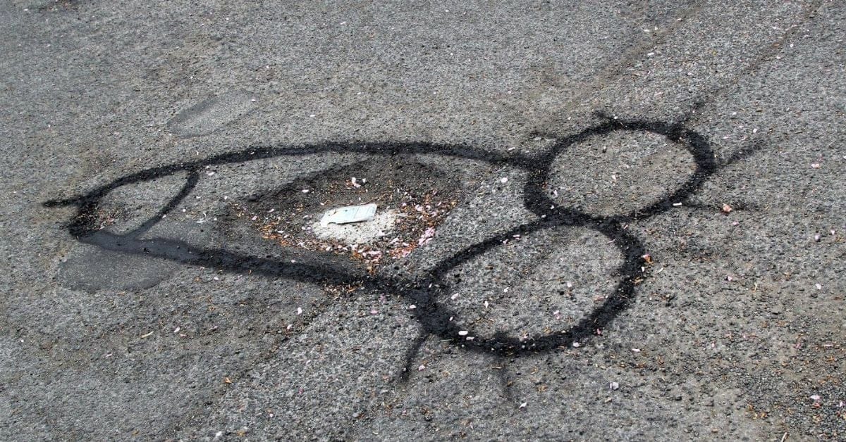 Guy Gets City To Fix Giant Potholes By Spray Painting Wieners Around Them
