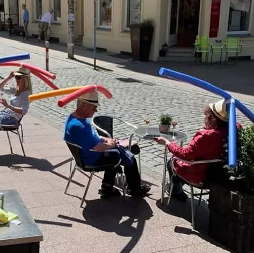 Reopened German Cafe Gives Customers Pool Noodle Hats To Enforce Social Distancing