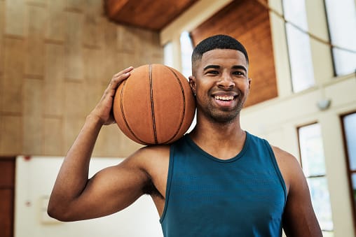 guy playing basketball smiling