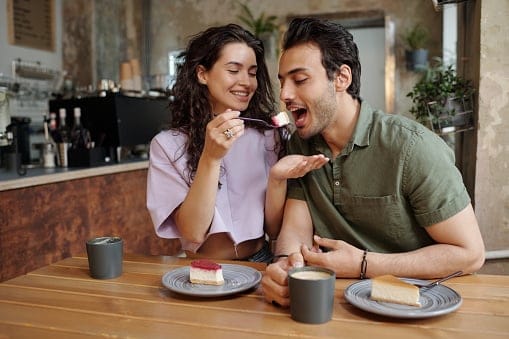 woman feeding boyfriend smiling