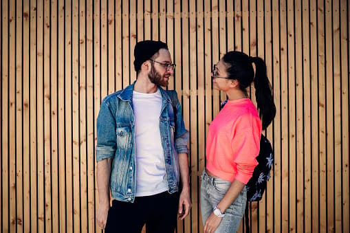 couple standing against wall sunglasses
