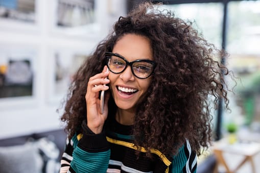 happy woman with glasses on phone
