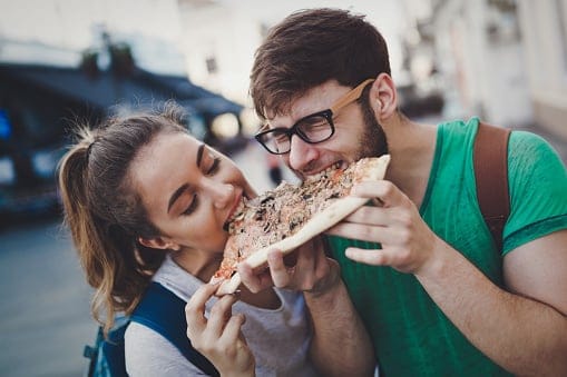 couple sharing slice of pizza