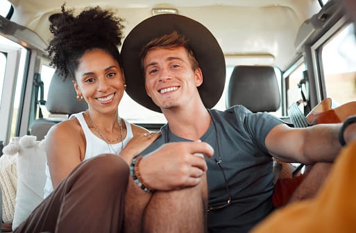 Couple, road trip or bonding in camper travel on safari game drive in nature desert environment or Kenya landscape location. Portrait, smile or happy interracial man or black woman on camping holiday