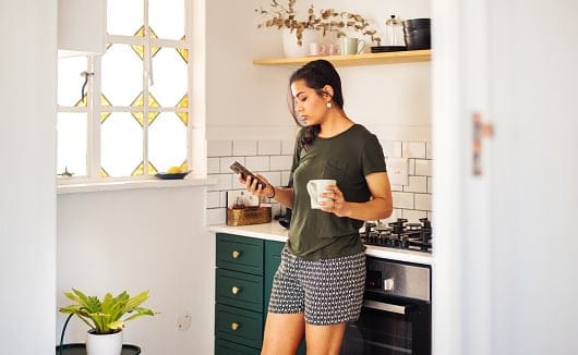 woman texting in her kitchen
