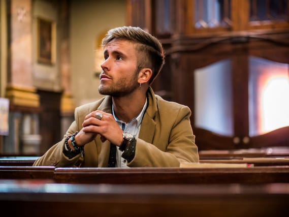 Young man sitting in church.