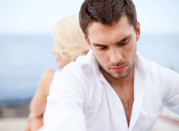 Man and woman sitting with backs to one another.