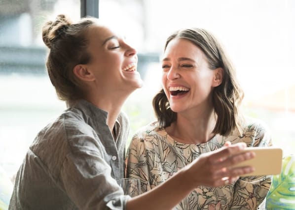 female friends laughing at cafe
